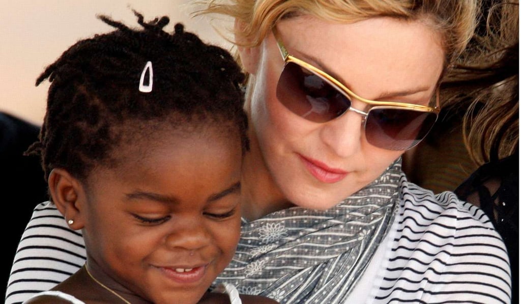 Pop star Madonna sits with her adopted Malawian child Mercy James during a bricklaying ceremony at the site of her Raising Malawi Girls Academy, near the capital Lilongwe in 2010. Photo: Reuters