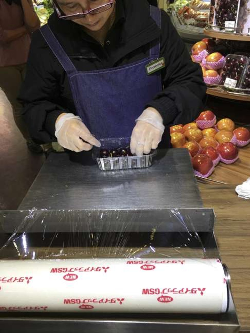 A staff member at City’super in Causeway Bay wraps cherries in plastic. Photo: SCMP