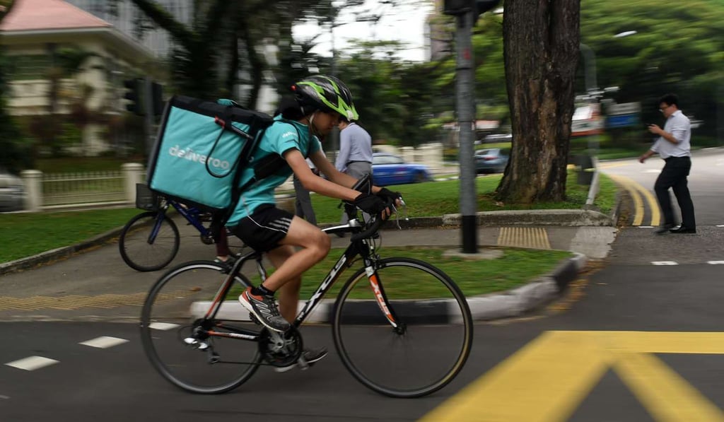 A delivery woman on a bicycle delivers food in Singapore. The city state’s workers are being urged to learn new skills. Photo: aFP A delivery woman on a bicycle delivers food in Singapore. The city state’s workers are being urged to learn new skills. Photo: aFP