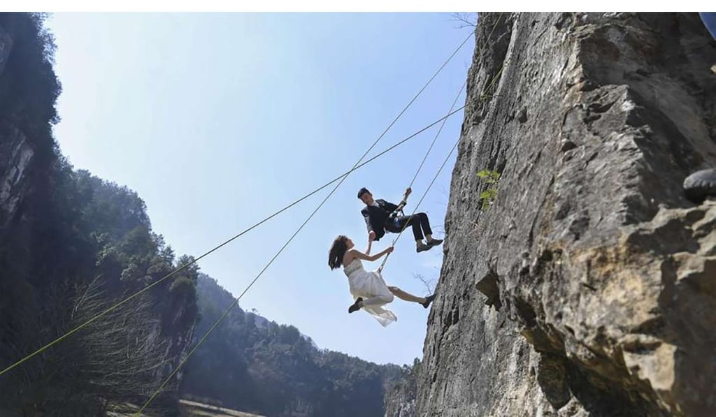 One of the couples suspended from the cliff. Photo: Chinanews.com