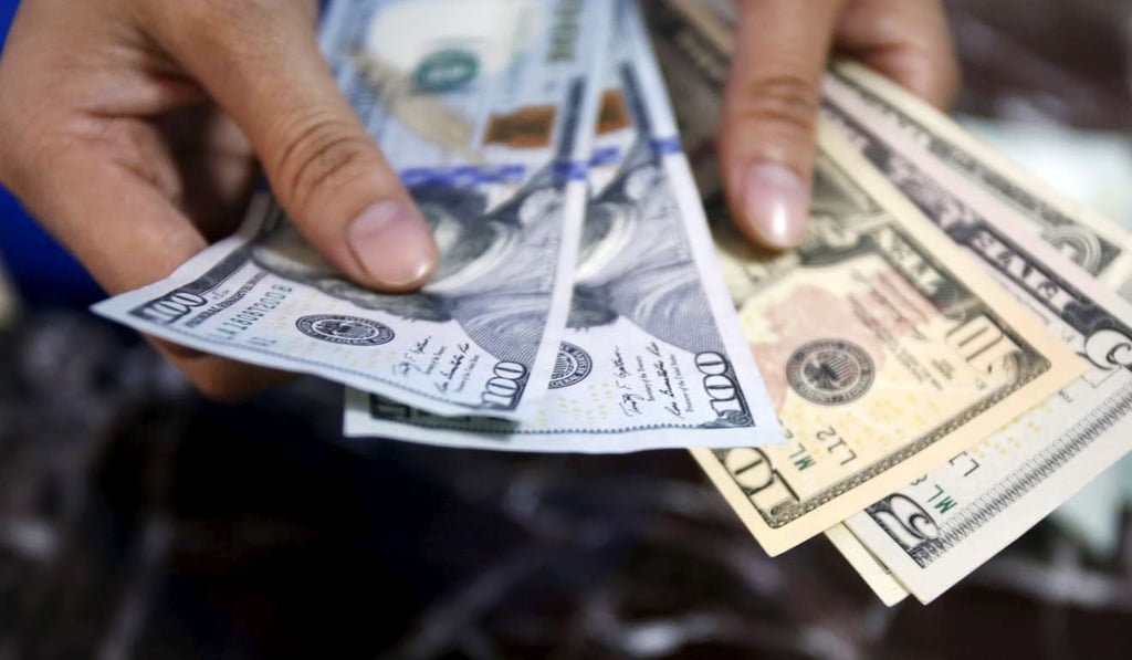 An employee checks US dollar bank notes at a bank in Hanoi, Vietnam. Photo: Reuters