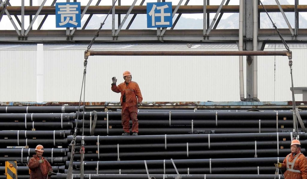 Chinese workers load steel tubes onto a truck at a logistics center in Lianyungang in east China's Jiangsu province. Photo: AFP