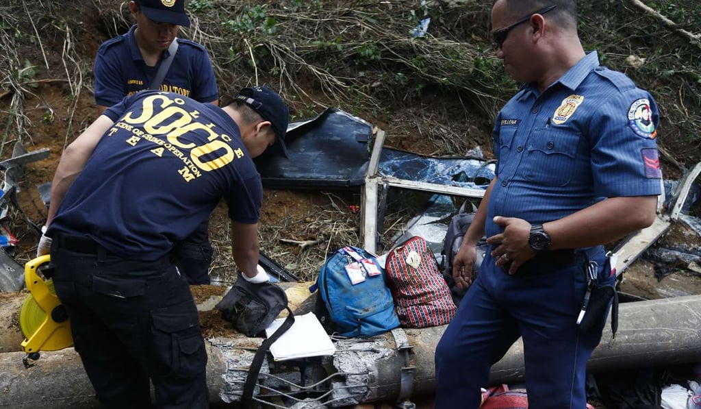 Police recover what is believed to be belongings of passengers of a bus following a transport accident in Tanay, Rizal Province. Photo: EPA