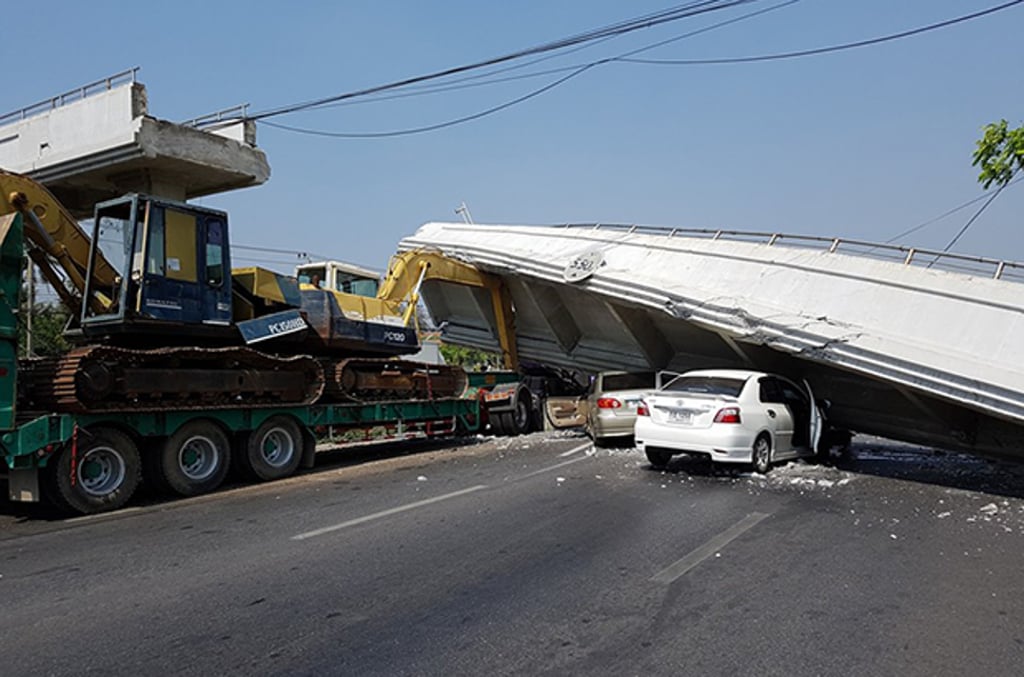 Backhoe loaded on back of truck hit pedestrian bridge bringing it down. Photo: the Facebook page of Chaeng Khao Sarn Ang Thong. Backhoe loaded on back of truck hit pedestrian bridge bringing it down. Photo: the Facebook page of Chaeng Khao Sarn Ang Thong.