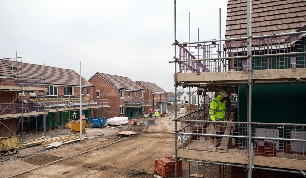 A workman moves around the scaffolding of a house at a Persimmon residential property construction site in Weston-Super-Mare, UK, on , January 26, 2017. Photo: Bloomberg