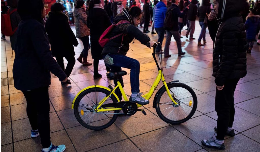 A girl rides an Ofo bike in Shanghai. The humble bicycle is seeing a revival in China as a new generation of start-ups help tackle urban congestion and pollution with fleets of brightly coloured two-wheelers. Photo: AFP