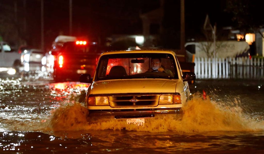 A motorist drives on a flooded street as water continues to rise after heavy rains overflowed nearby Coyote Creek in San Jose, California. Photo: Reuters
