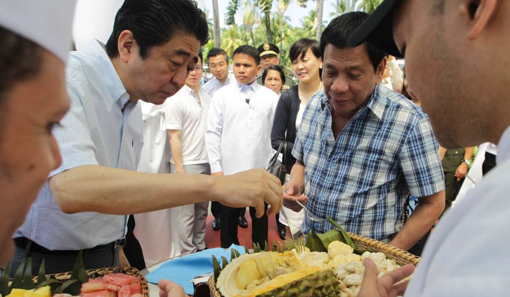 Japanese Prime Minister Shinzo Abe, left, eats durian with Philippine President Rodrigo Duterte in Davao City, the Philippines. Photo: AFP Japanese Prime Minister Shinzo Abe, left, eats durian with Philippine President Rodrigo Duterte in Davao City, the Philippines. Photo: AFP