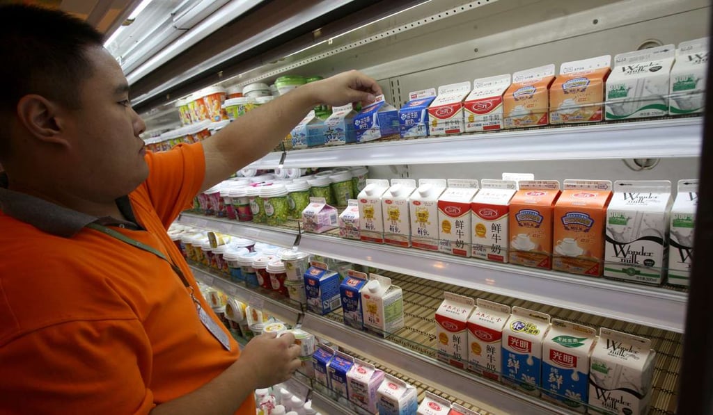 A worker sorts dairy products, including Mengniu and Bright Dairy milk products, for suspected contamination at a market in Beijing, China, on Wednesday, September 17, 2008. Photo: Bloomberg News