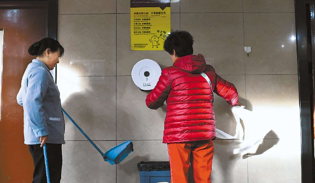 A woman stocks up on supplies as a cleaner waits patiently. Photo: Handout