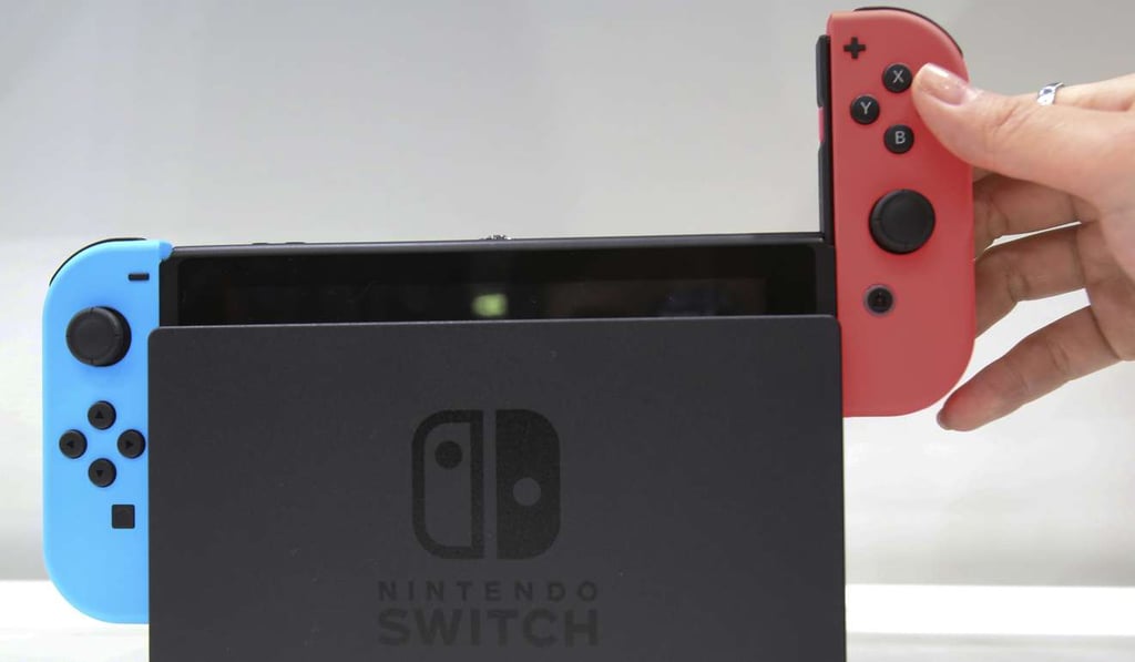 Placing the controller onto the Nintendo Switch. Photo: AP Placing the controller onto the Nintendo Switch. Photo: AP