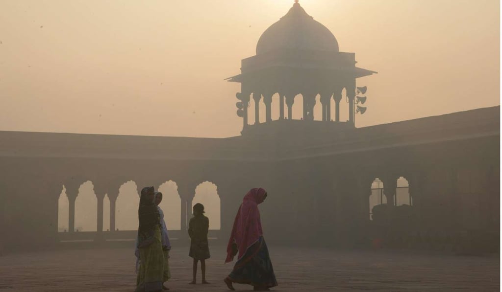 Indian women walking as smog envelops the Jama Masjid mosque in the old quarters of New Delhi. Photo: AFP