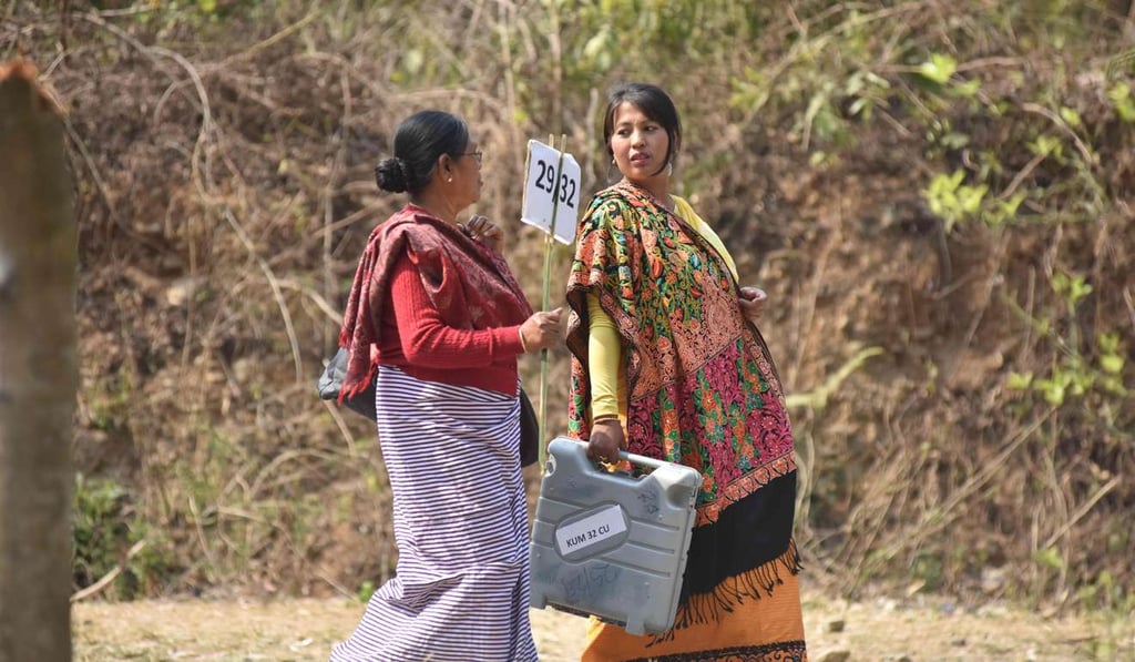 A polling officer carrying an Electronic Voting Machine walks to a polling station on the eve of the State Assembly Election in Bishnupur district. Photo: AFP