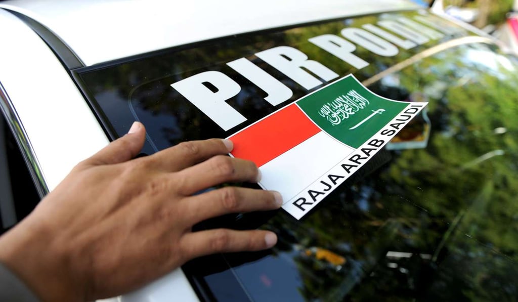 A policeman prepares his patrol car ahead of Saudi King Salman’s visit to Bali. Photo: AFP A policeman prepares his patrol car ahead of Saudi King Salman’s visit to Bali. Photo: AFP