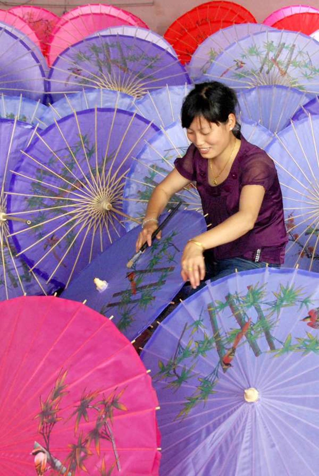 A woman makes paper umbrella at a factory in Wuyuan, east China's Jiangxi Province. Photo: Zhang Weiguo