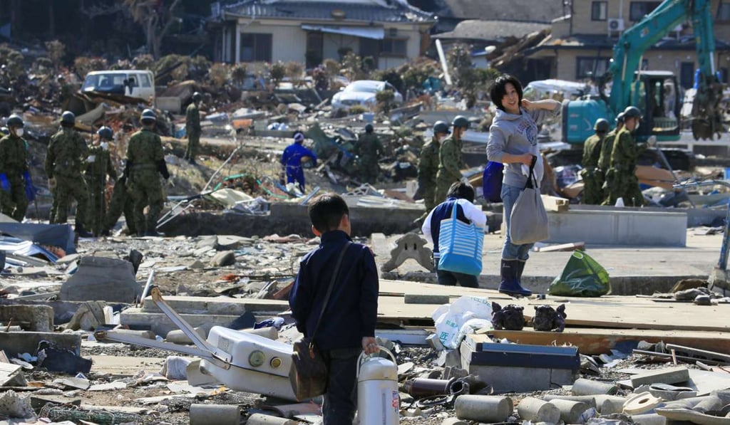 A mother and son retrieve belongings from their destroyed home in Ishinomaki, in Japan’s Miyagi prefecture on April 10, 2011, a month after a devastating magnitude-9 earthquake and tsunami. Photo: EPA