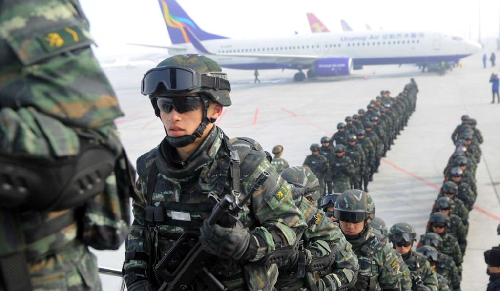Paramilitary police board a plane as they head for an anti-terrorism oath taking rally in Kashgar in Xinjiang last month. Photo: Reuters