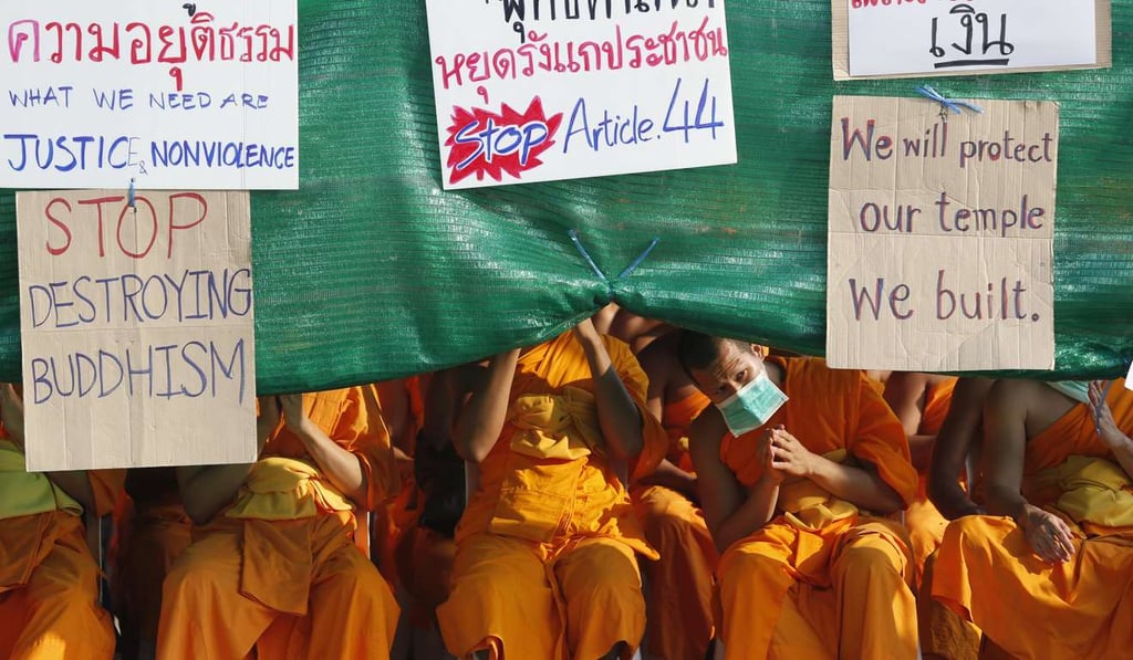 Thai Buddhist monks from the Dhammakaya Temple with protest banners during a confrontation with policemen outside Wat Phra Dhammakaya Temple in Pathum Thani province. Photo: EPA
