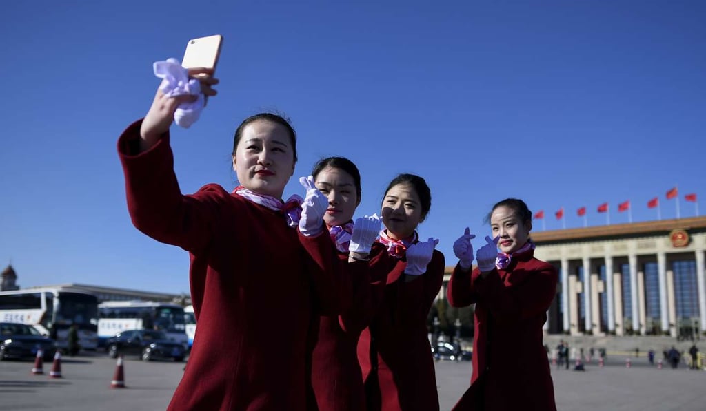 A group of attendants use a mobile phone to take a picture during the third plenary session of the National People's Congress outside the Great Hall of the People on March 12, 2017. Photo: AFP A group of attendants use a mobile phone to take a picture during the third plenary session of the National People's Congress outside the Great Hall of the People on March 12, 2017. Photo: AFP