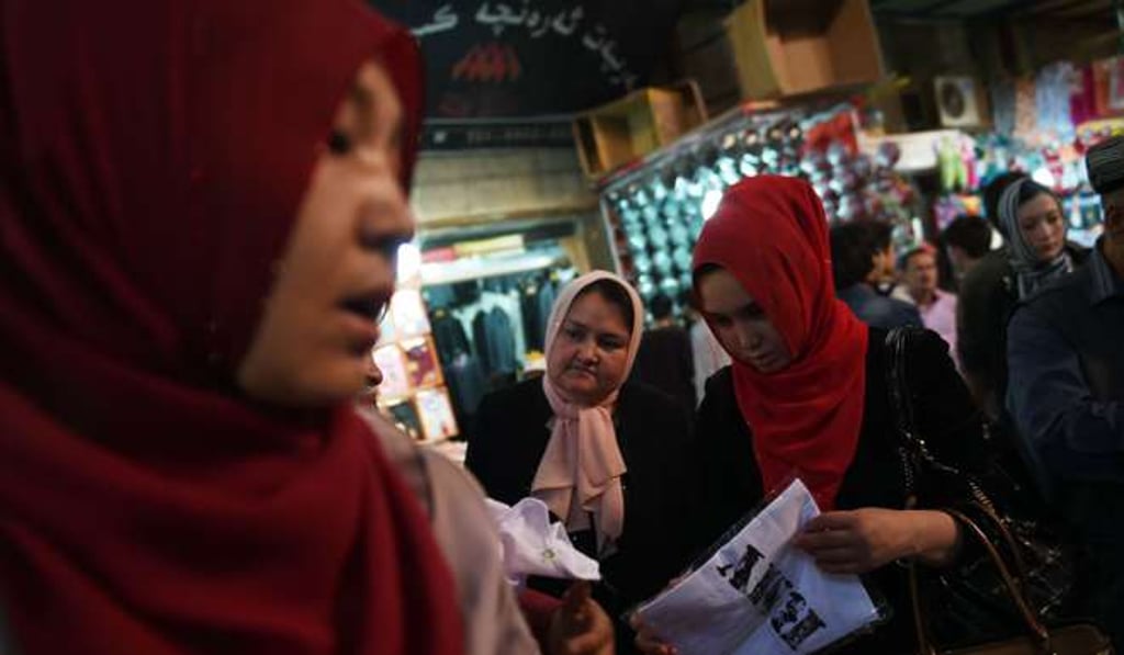 Uygur women wearing headscarves shop at a bazaar in Hotan, Xinjiang, in April 2015. Photo: AFP