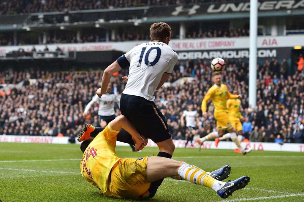 Tottenham striker Harry Kane is tackled by Millwall’s Jake Cooper. Photo: AFP