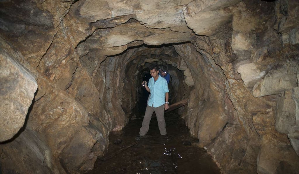 Geologist Jackie Chu (front) with writer Stuart Heaver in an old mining adit in Needle Hill. Picture: Antony Dickson