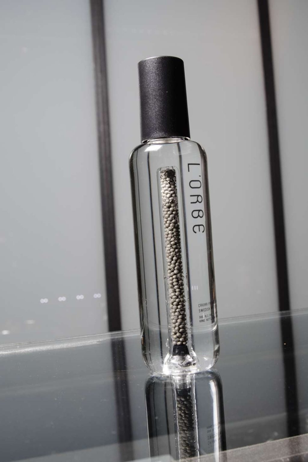 A perforated column of caviar beads sits in the centre of a bottle of L'Orbe vodka. Photo: Bloomberg