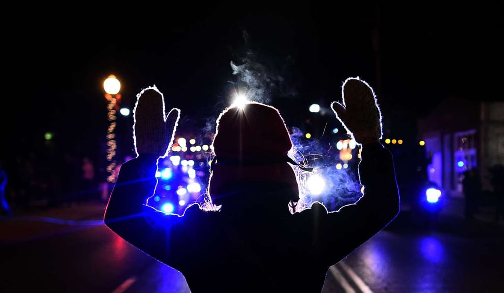 A protester holds her hands up in front of a police car in Ferguson, Missouri, on November 25, 2014 during demonstrations a day after violent protests and looting over the fatal shooting of a 18-year-old black teenager Michael Brown. Photo: AFP
