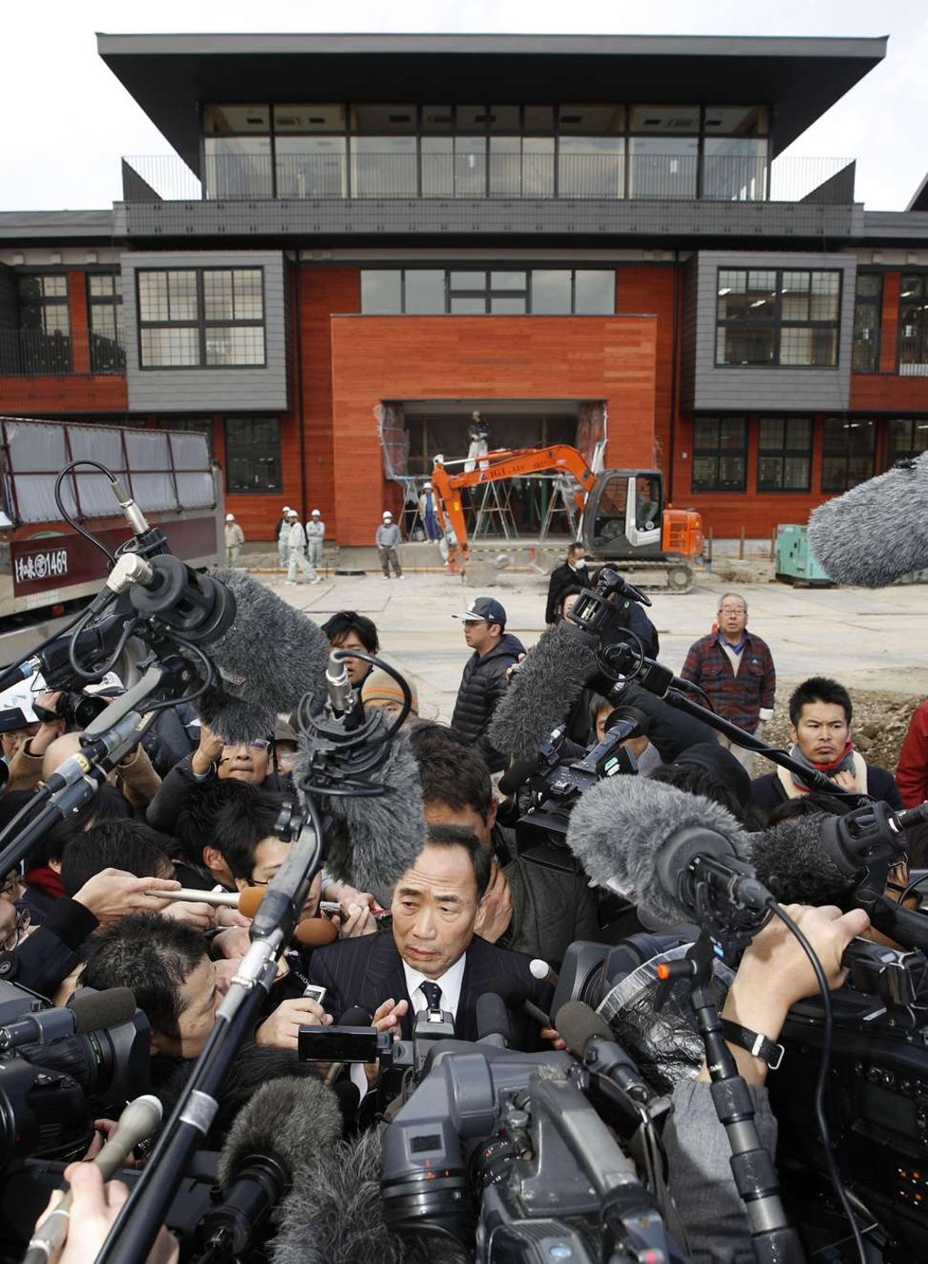 Yasunori Kagoike, president of education company Moritomo Gakuen,, is surrounded by reporters at the site of a controversial school under construction in Toyonaka, Osaka Prefecture, on March 9. Photo: Kyodo