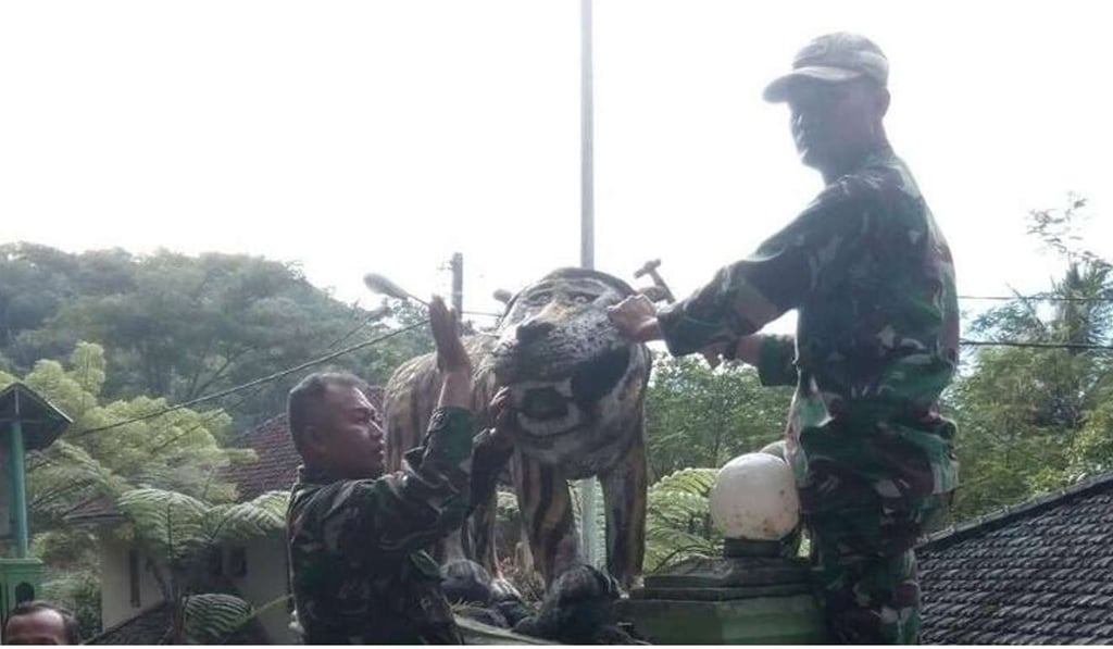 Military personnel using hammers and chisels to take the statue down. Photo: Twitter Military personnel using hammers and chisels to take the statue down. Photo: Twitter