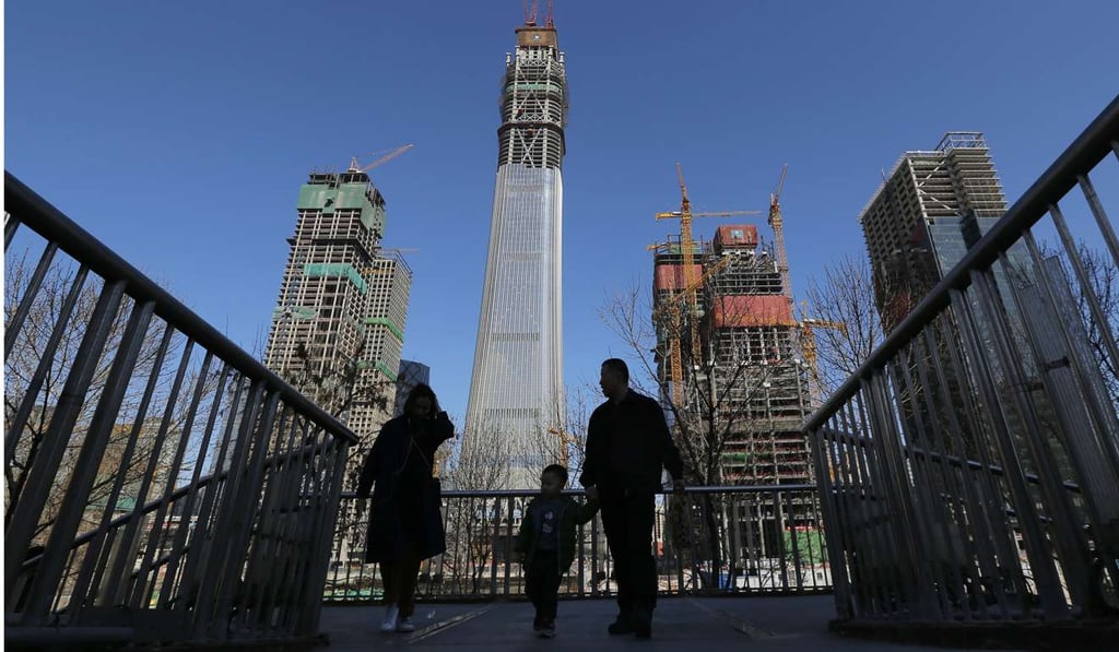 People walk on a footbridge in the central business district in Beijing. While reform has long been a key feature of the government work reports, the pervasiveness of reform in this year’s report makes it special. Photo: EPA