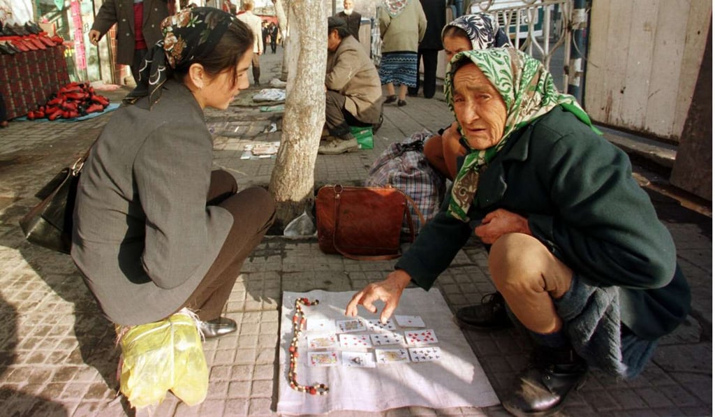 A Uygur fortune-teller, right, reads playing cards as she tells a young woman her fortune in Xinjiang. Photo: AFP