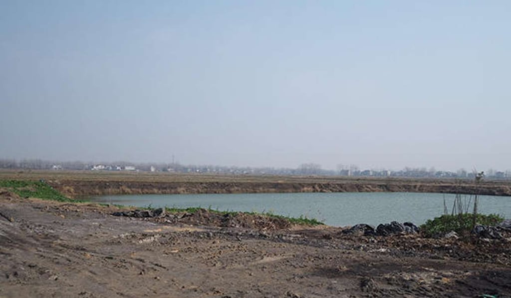 The waste dirt was quietly dumped in a field at the brick plant, which is next to a fish pond and rice paddies. Photo: News.qq.com