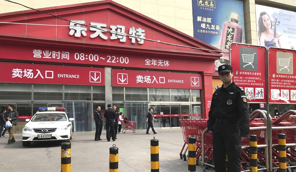A police car is stationed outside a Lotte Mart store in Beijing, along with security guards, on March 17. Dozens of Lotte Mart discount stores in China were temporarily shut in early March after surprise inspections found fault with fire safety standards. Just days before, Lotte Group, South Korea’s fifth-largest company, agreed to let one of its golf courses be a site for deploying America’s THAAD anti-missile system. Photo: AP
