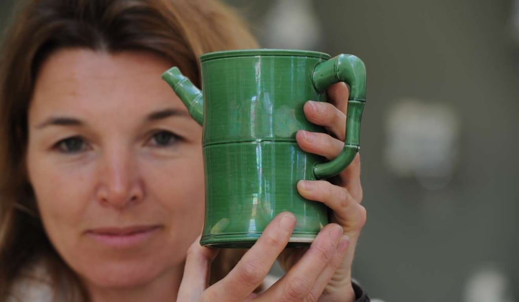 Katharine Butler holds the green enamelled wine pot, dating from about 1670, that was the first piece her late father, Sir Michael Butler, bought in May 1960. Picture: Mike Clarke