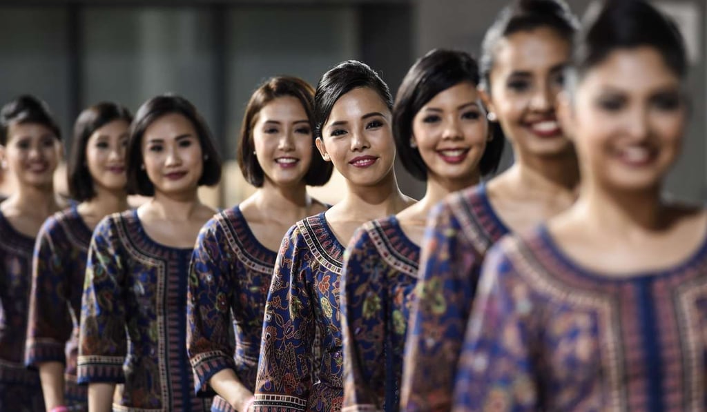 Cabin crew from Singapore Airlines, a title sponsor of the Singapore Grand Prix, attend the races in September last year. Commercially, Singapore Airlines is Singapore’s face to the world, offering the first glimpse of what this country offers to foreigners. Photo: AFP