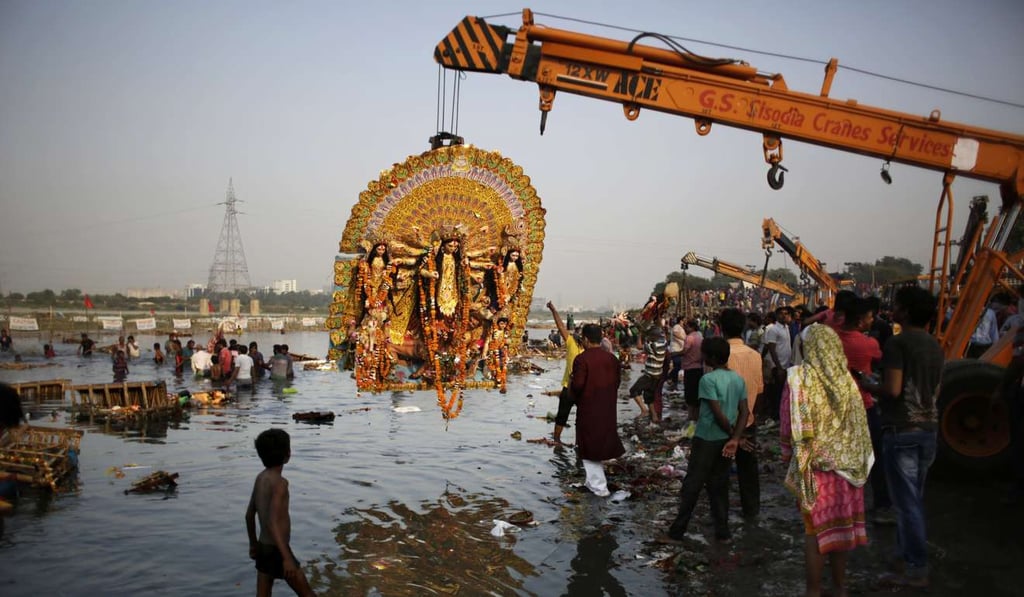 A giant idol of Hindu goddess Durga is suspended from a crane before it is immersed in the River Yamuna during Durga Puja festival in New Delhi. Photo: AP A giant idol of Hindu goddess Durga is suspended from a crane before it is immersed in the River Yamuna during Durga Puja festival in New Delhi. Photo: AP