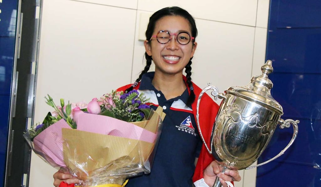 Ng On-yee is all smiles at Chek Lap Kok airport after lifting the world title in Singapore.