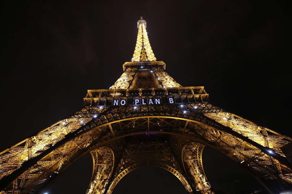 The Eiffel Tower displays an urgent message during the UN Climate Conference in Paris, on December 11, 2015. Uncertainty over the Paris Agreement and concerns about the financing of new renewable projects offer developing countries a chance to carve out their own climate strategy. Photo: AFP