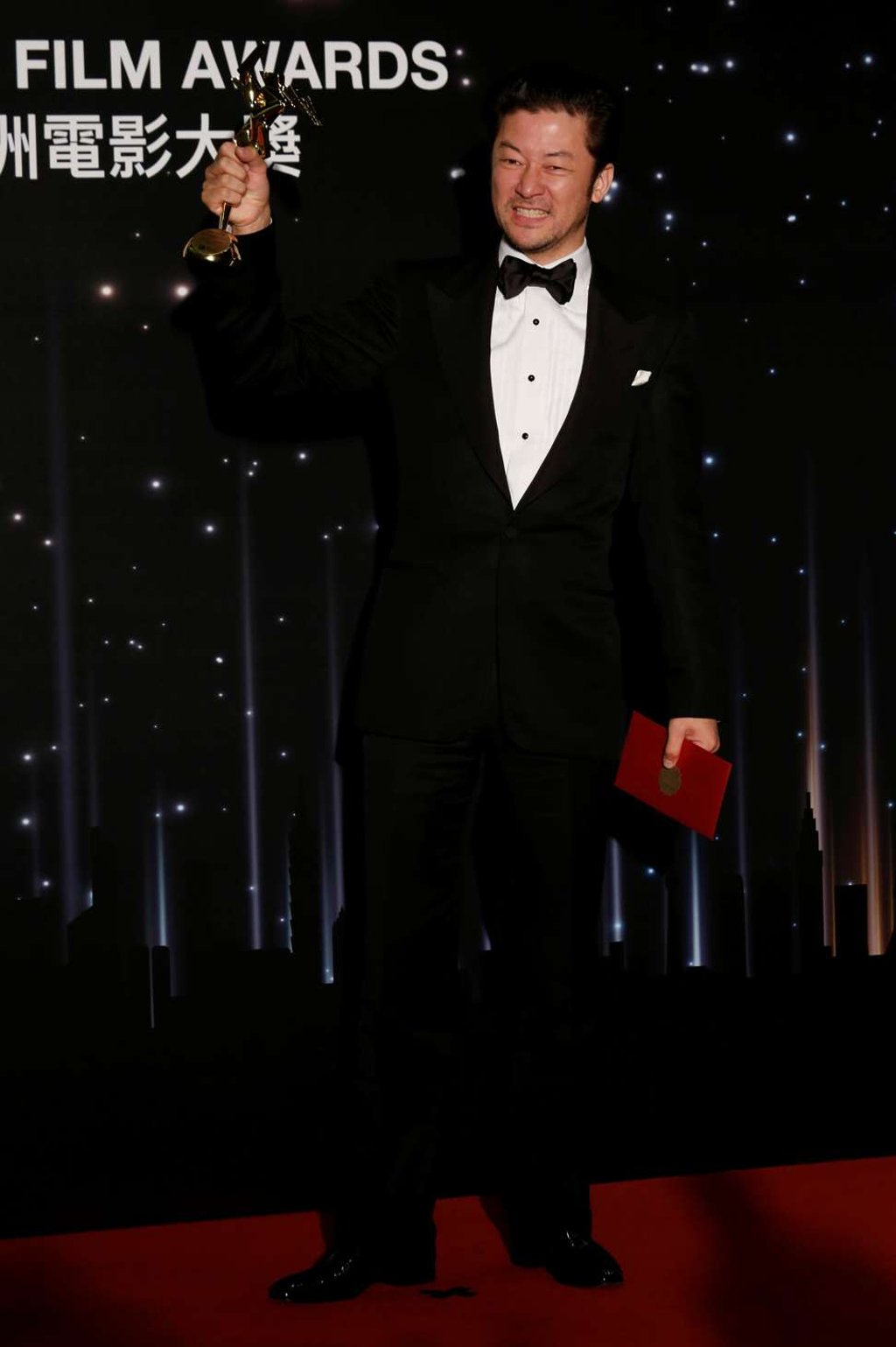 Japanese actor Tadanobu Asano celebrates with his best actor award at the Asian Film Awards. Photo: REUTERS