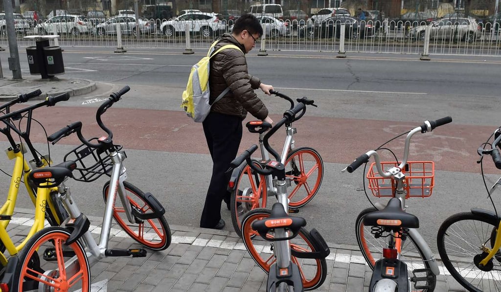 A customer pictured using a Mobike shared bicycle in Beijing earlier this month. Photo: Xinhua A customer pictured using a Mobike shared bicycle in Beijing earlier this month. Photo: Xinhua