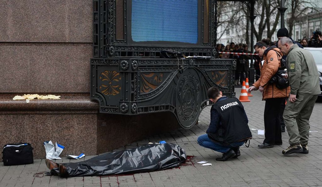 Ukrainian policemen stand around the slain body of Denis Voronenkov in Kiev on Thursday. Photo: EPA