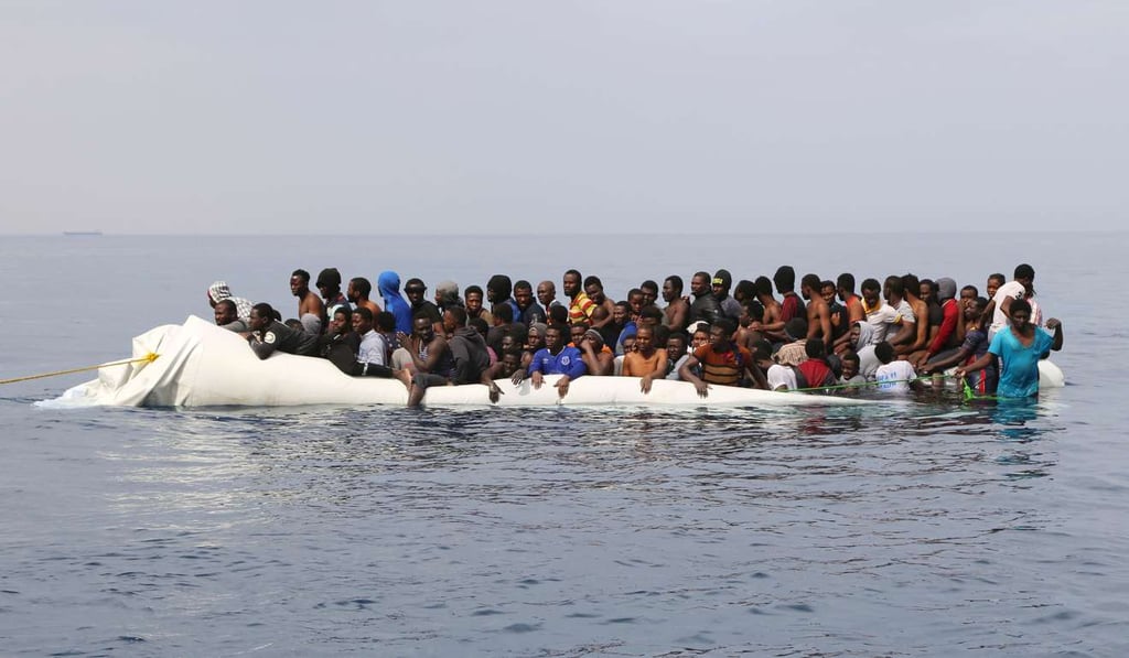Migrants wait to be rescued from a sinking dingey off the Libyan coast. Photo: AFP