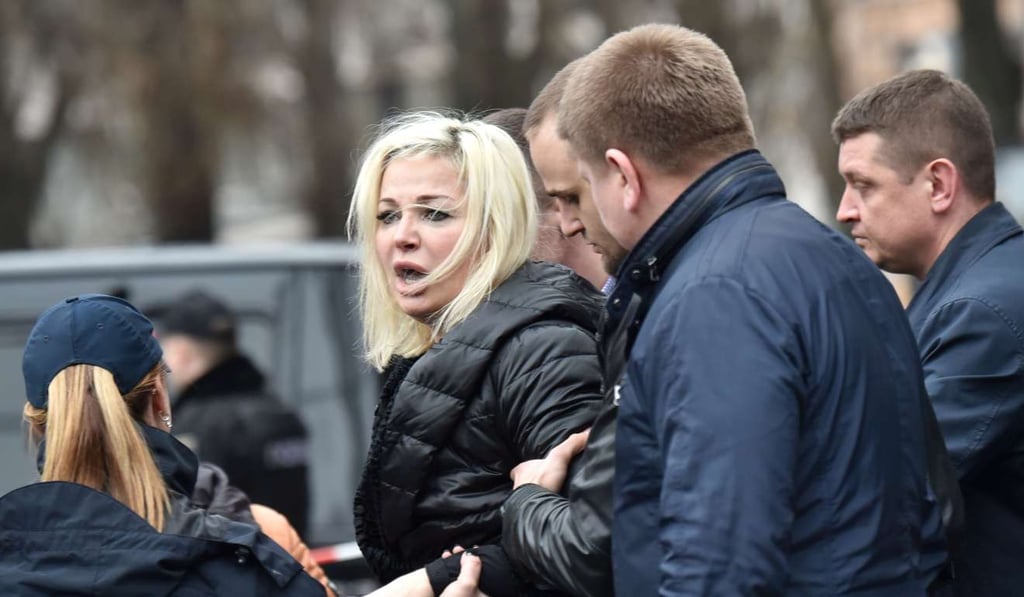 Maria Maksakova, the distraught wife of Denis Voronenkov, is led away by police from the scene of her husband’s murder in Kiev on Thursday. Photo: AFP