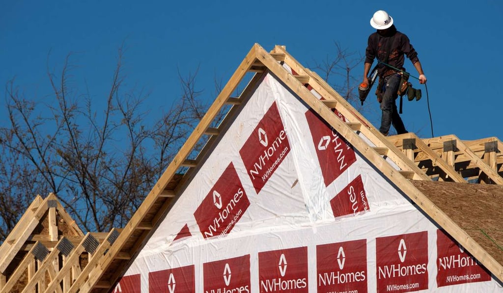 A construction worker installing a rooftop on to a new home being built in Fairfax, Virginia. New home sales hit a 7-month peak. Photo: AFP