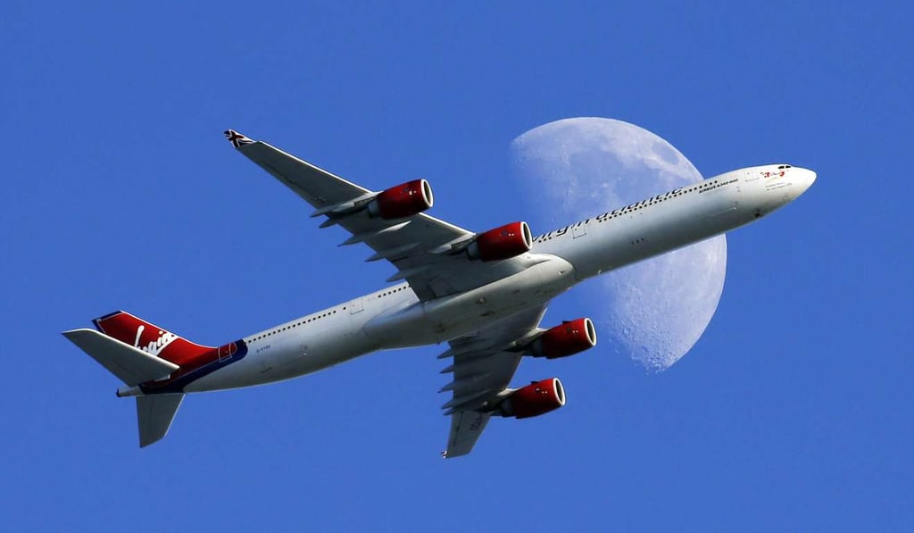 A Virgin Atlantic passenger plane crosses a waxing gibbous moon on its way to the Los Angeles International Airport, in Whittier, California. Alaska Airlines said it will retire the Virgin brand, probably in 2019. Photo: AP