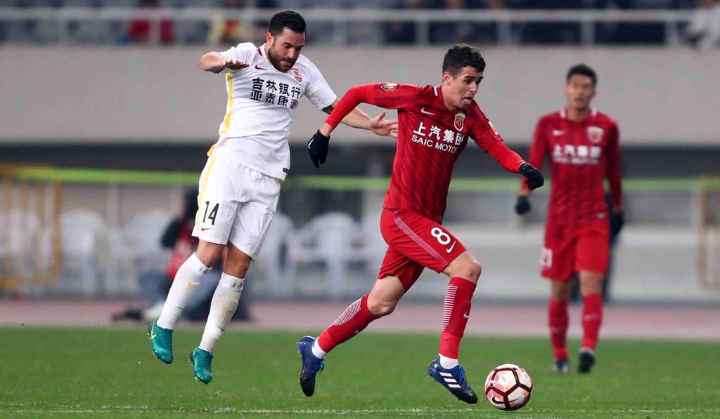Changchun Yatai’s Jack Sealy (left) with Shanghai SIPG’s Brazilian midfielder Oscar. Photo: AFP