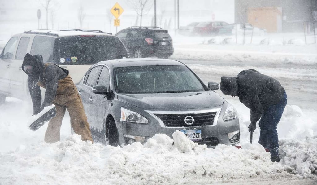 People help dig out a car stuck in a snow drift on Friday, March 24, 2017 in Colorado Springs, Colorado. Blowing snow, low visibility and vehicles sliding off the road initially shut down about 400 miles of roads in southern and eastern Colorado Friday. Photo: The Gazette via AP