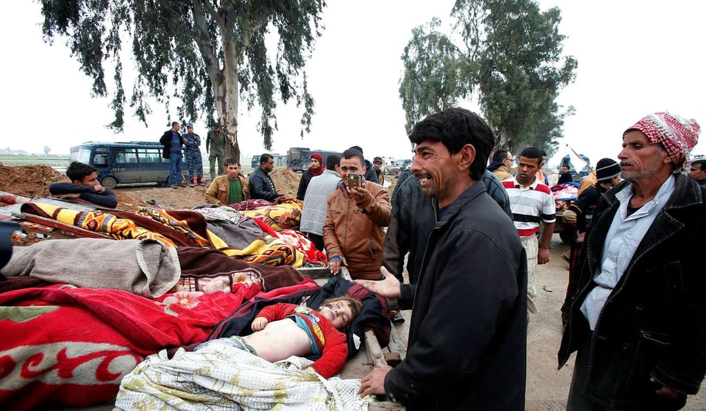 Relatives weep over the bodies of loved ones killed in air strikes in Mosul on March 17. Photo: Reuters
