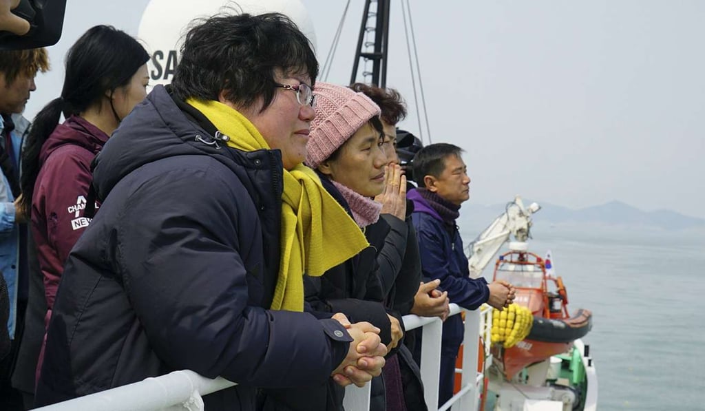 Families of three missing ferry passengers looking at the retrieved Sewol ferry. Photo: EPA